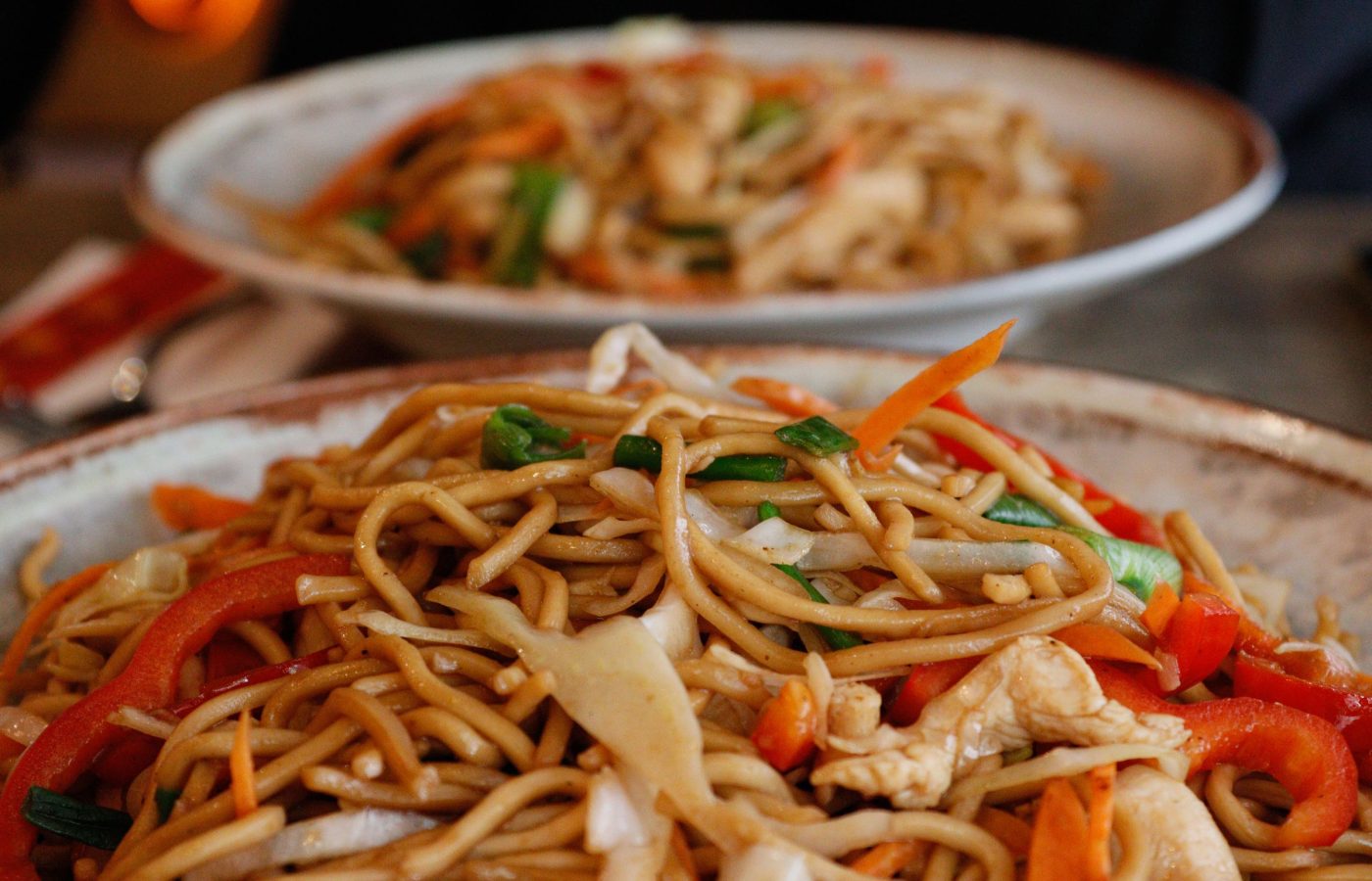 Wok-Nudelpfanne mit Gemüse und Hähnchen, asiatisch angerichtet