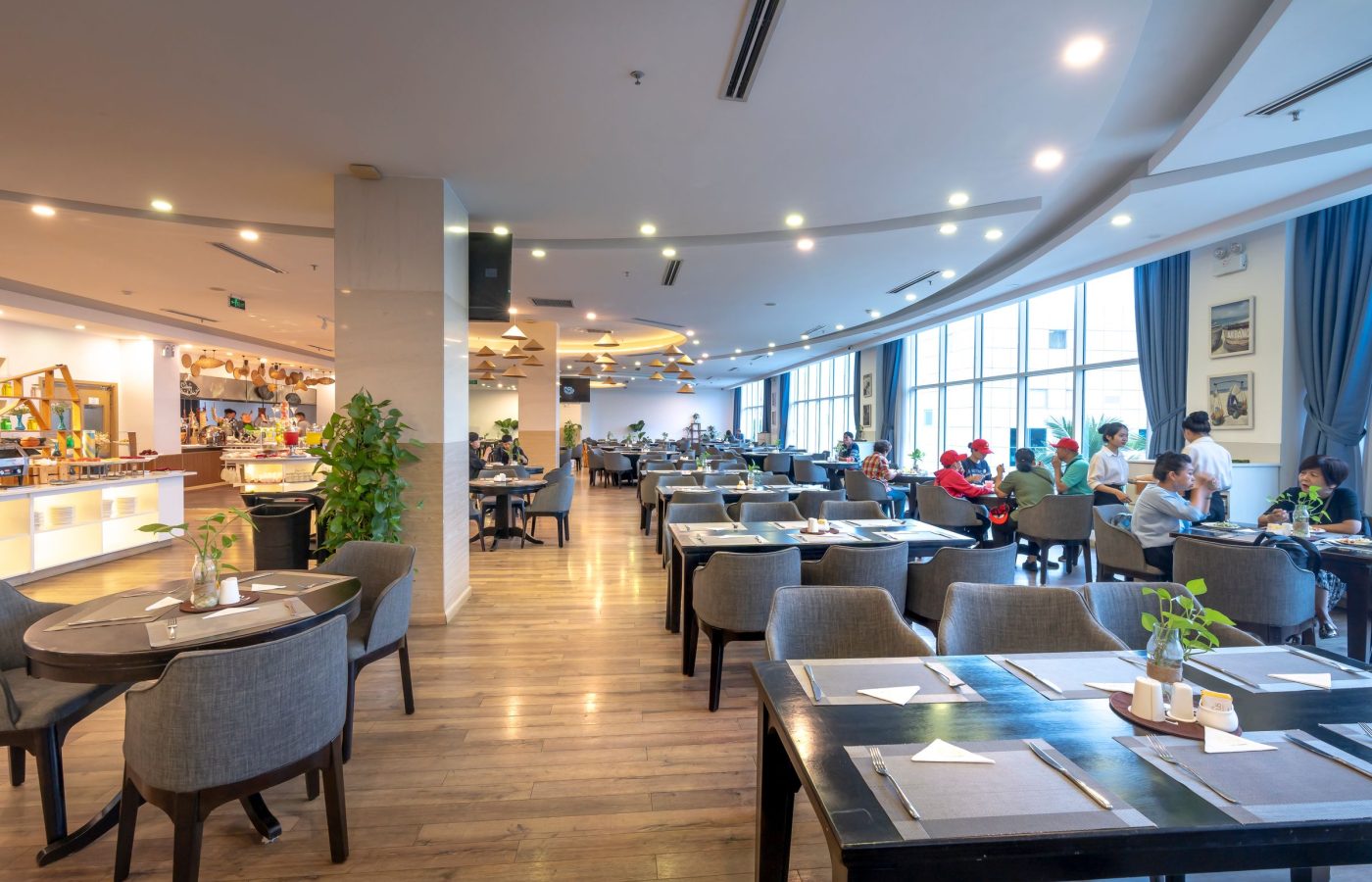 Helles, modernes Restaurant mit eingedeckten Tischen und großen Fenstern