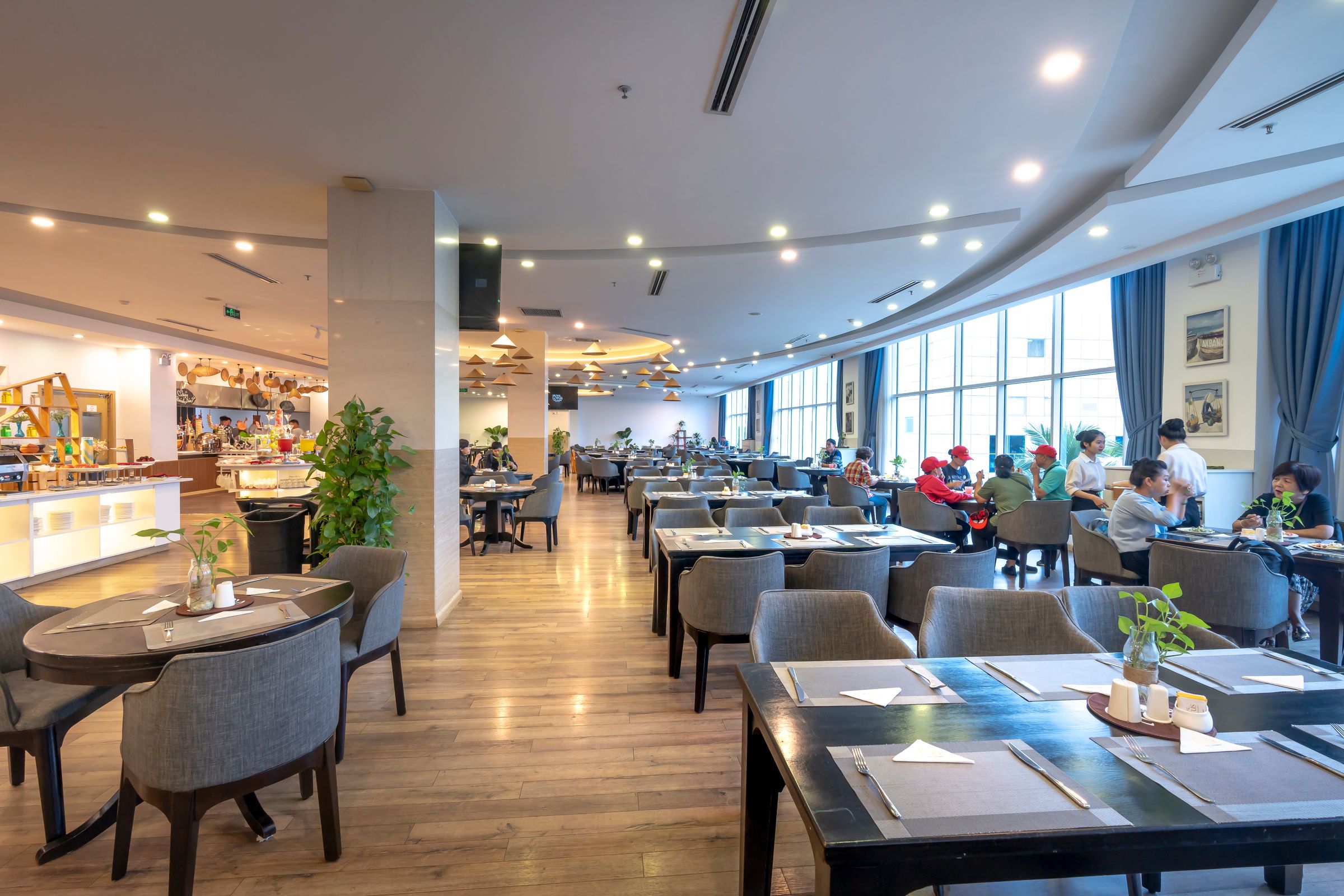 Helles, modernes Restaurant mit eingedeckten Tischen und großen Fenstern